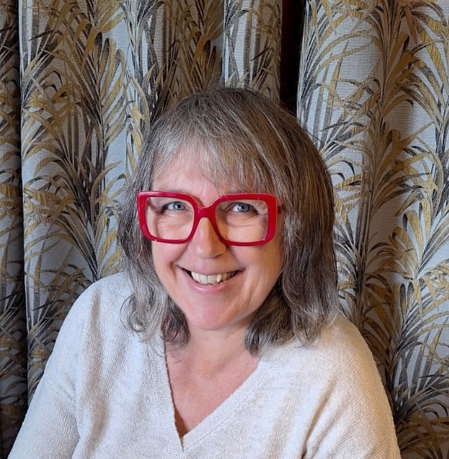 Portrait d'une femme souriante portant des lunettes rouges